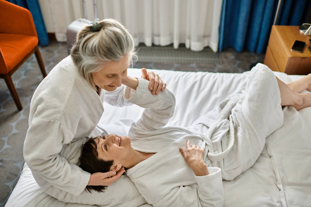 Senior lesbianas pareja tiernamente acostado juntos en un cama. - Foto, imagen