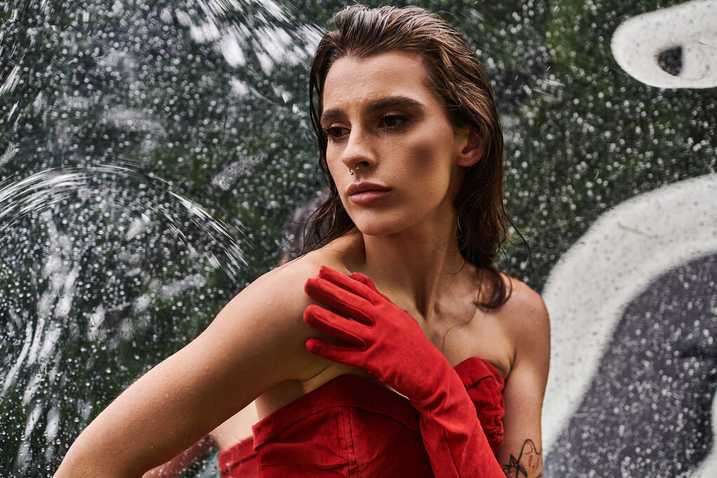 Красивая молодая женщина в красном платье и длинных перчатках наслаждается летним бризом у фонтана. - Фото, изображение