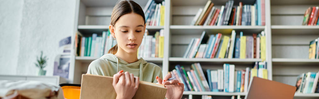 Genç bir kız önünde bir kitapla masada oturuyor, okuldan sonra derslerine dalıyor.. - Fotoğraf, Görsel