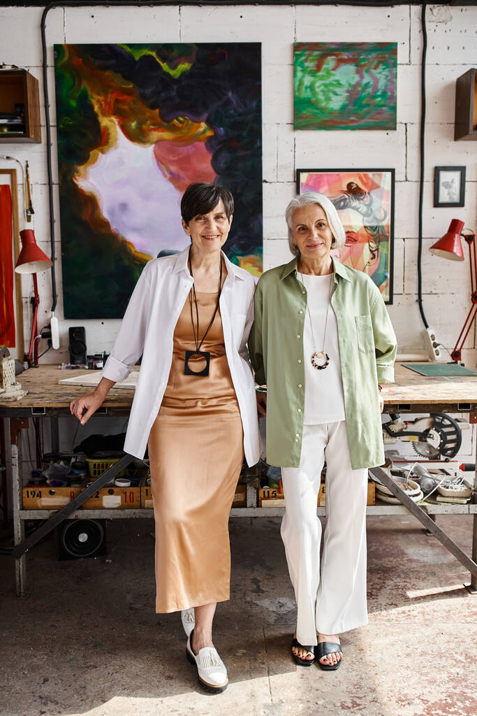 Две зрелые женщины мирно стоят в художественной студии. - Фото, изображение