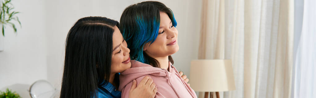 Una madre asiática y su hija adolescente, vestidas con atuendo casual, disfrutan de un tiempo de calidad juntos en casa. - Foto, Imagen