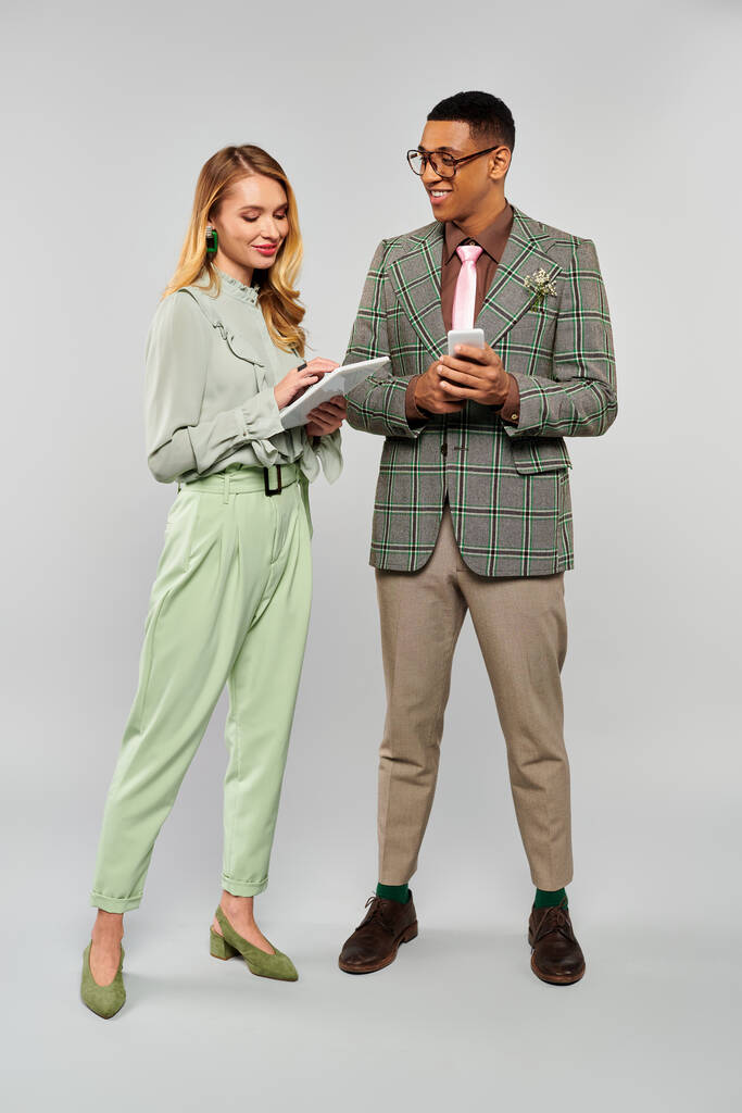 Зачарована пара в яскраво-зелених костюмах і штанах стоїть з любов'ю разом. - Фото, зображення