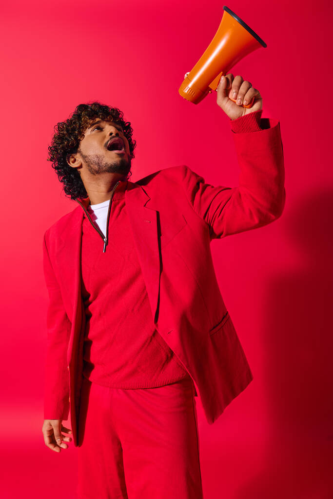 Levendige Indiase man in rood pak met een megafoon. - Foto, afbeelding