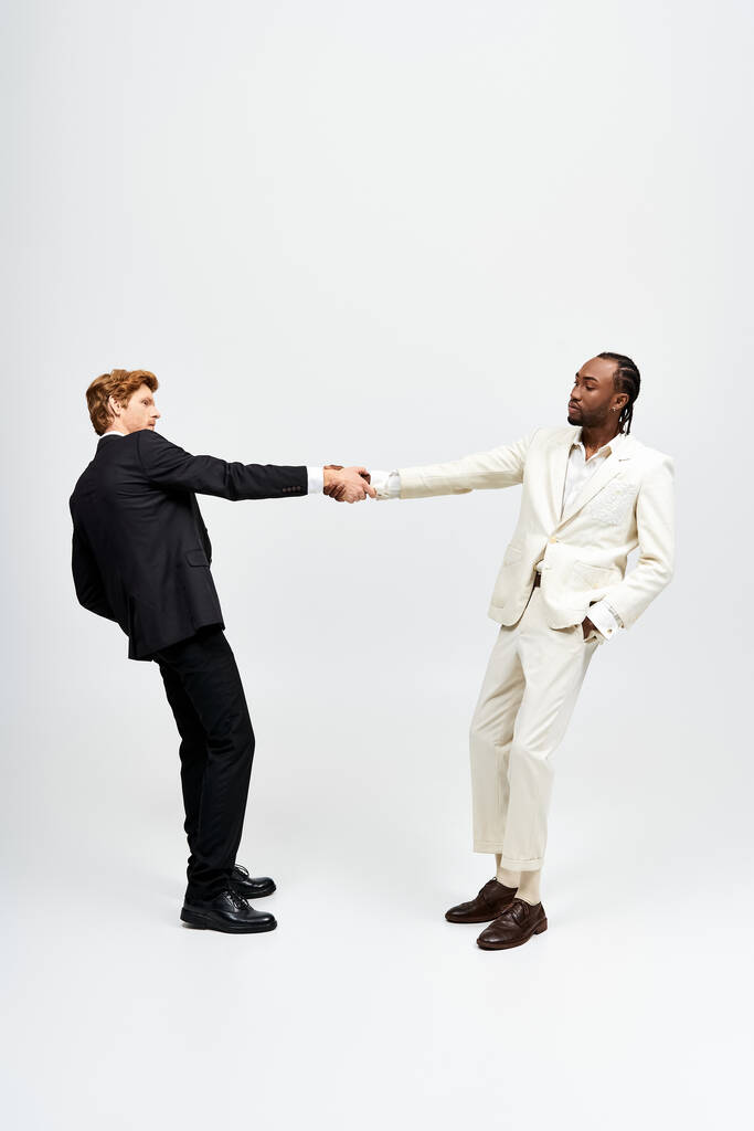 Dois homens multiculturais em ternos elegantes apertando as mãos. - Foto, Imagem