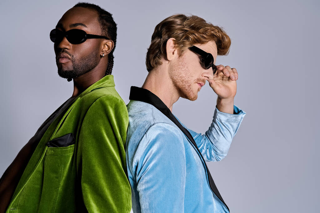 Dwóch wielokulturowych mężczyzn w zielonych kurtkach w stylowych okularach przeciwsłonecznych. - Zdjęcie, obraz