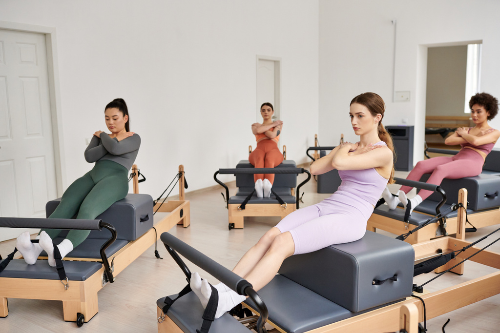 Un vibrante gruppo di donne piuttosto sportive impegnate in una lezione di Pilates in una stanza. - Foto, immagini