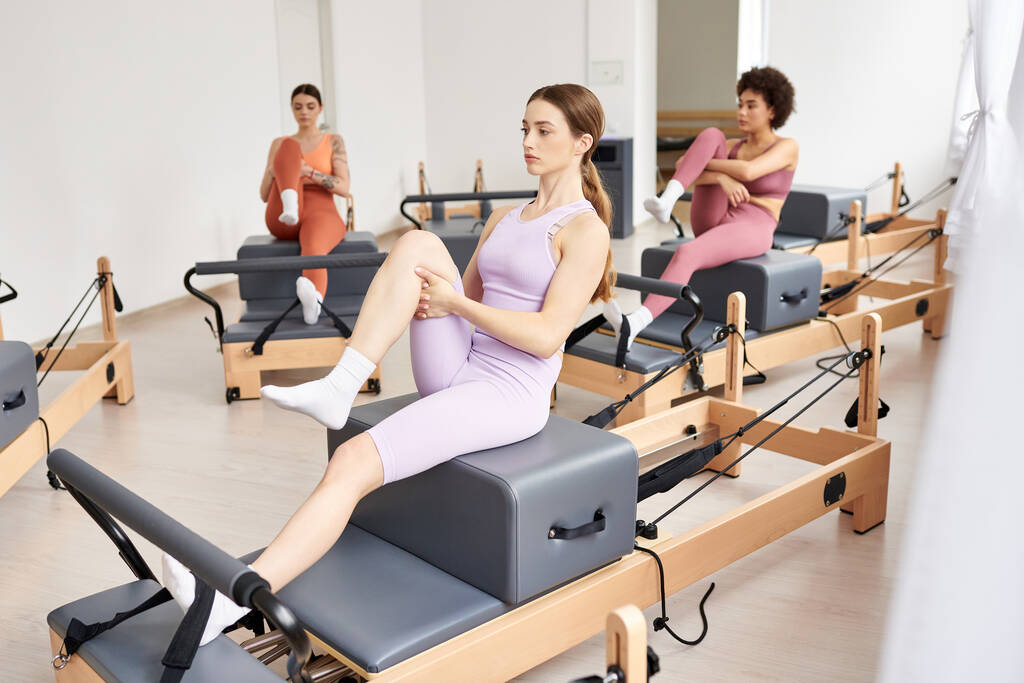 Group of pretty women engaging in a dynamic pilates session at the gym. - Photo, Image