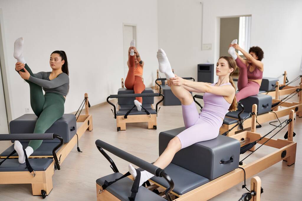 Atletische vrouwen die elegant trainen tijdens een Pilates-sessie in een fitnessruimte. - Foto, afbeelding