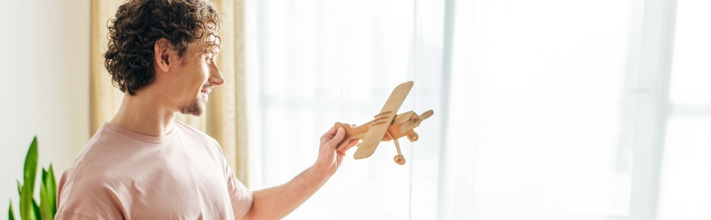 Um homem de roupa de casa aconchegante tem um avião de brinquedo na mão. - Foto, Imagem