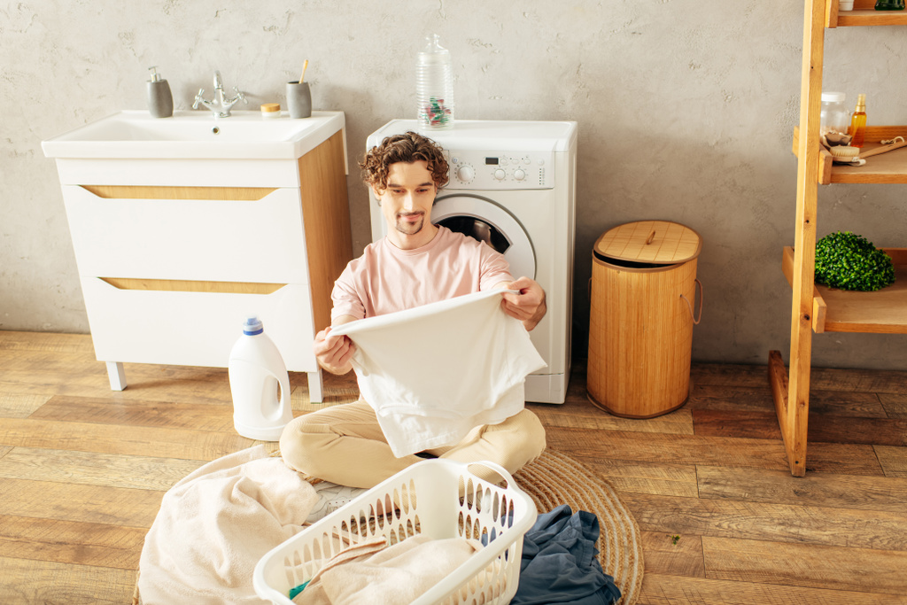 Jongeman gefascineerd door de wasmachine. - Foto, afbeelding