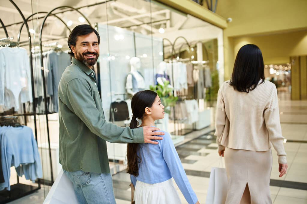 Een vrolijke vader en zijn dochter snuffelen door winkels in een bruisend winkelcentrum tijdens een leuk weekendje weg. - Foto, afbeelding