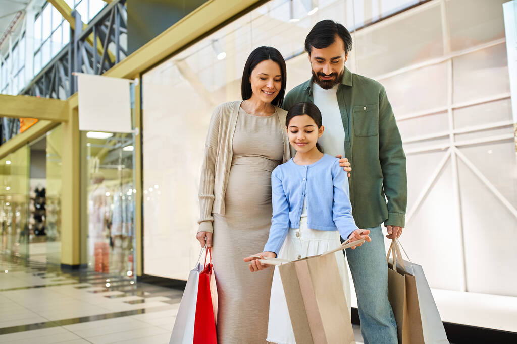 Uma família feliz com sacos de compras desfrutando de um passeio de fim de semana em um shopping movimentado, criando memórias especiais juntos. - Foto, Imagem