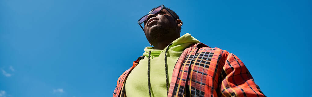 Yakışıklı Afrikalı Amerikalı şık giyinmiş, gökyüzüne bakıyor.. - Fotoğraf, Görsel