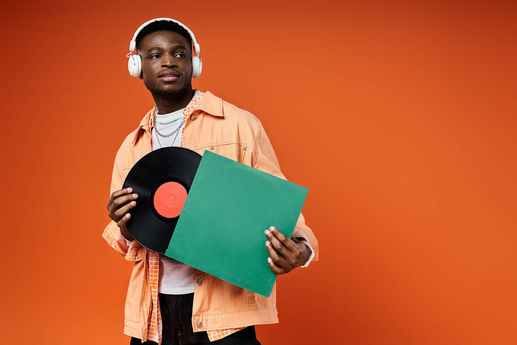 Jeune homme noir élégant tenant un disque vinyle. - Photo, image