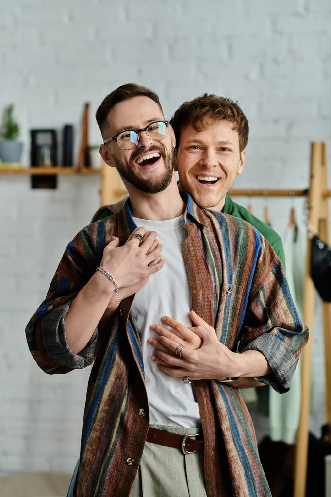 Dois homens, um casal gay, estão lado a lado em uma oficina de designer, criando trajes da moda juntos. - Foto, Imagem