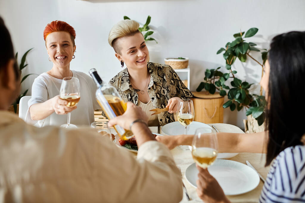 Μια ομάδα γυναικών διαφόρων εθνικοτήτων που απολαμβάνουν το κρασί σε ένα τραπέζι. - Φωτογραφία, εικόνα