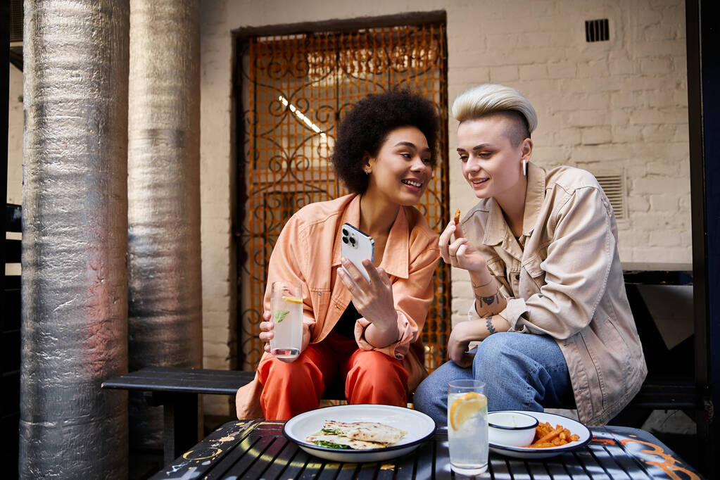 Un beau couple diversifié de lesbiennes partageant un moment dans un café. - Photo, image