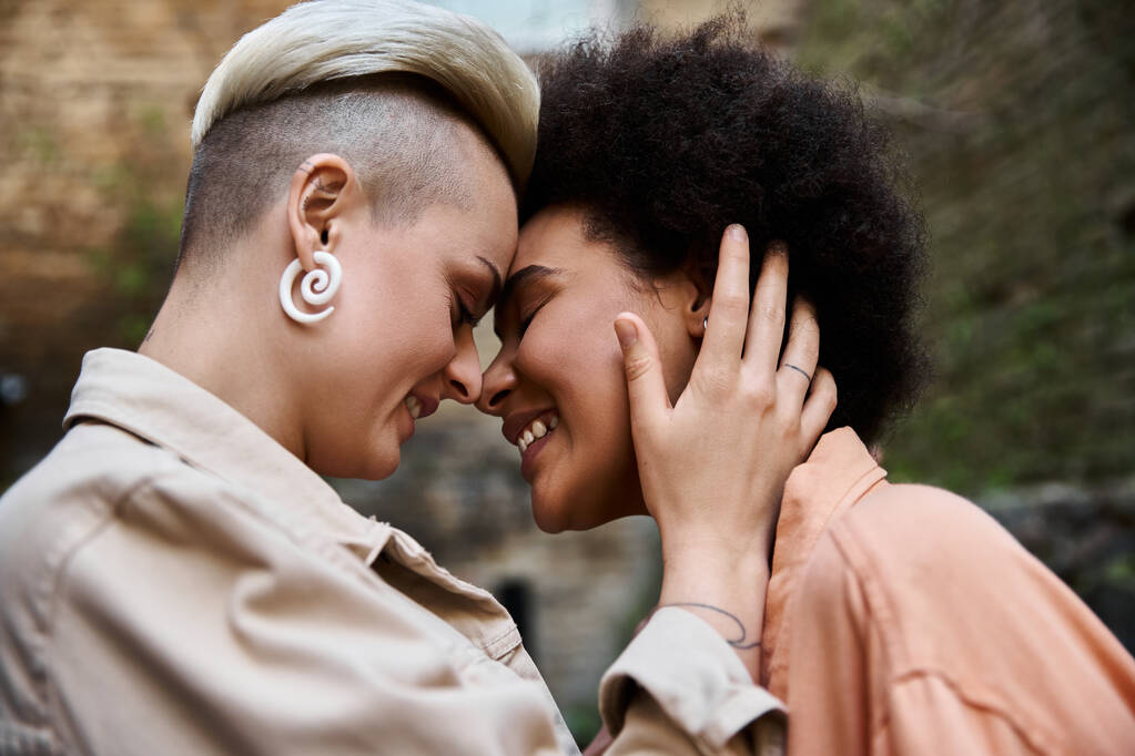 Разнообразная, красивая лесбийская пара стоит вместе, излучая любовь и связь. - Фото, изображение