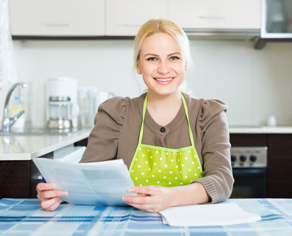 Женщина с документами на кухне
 - Фото, изображение