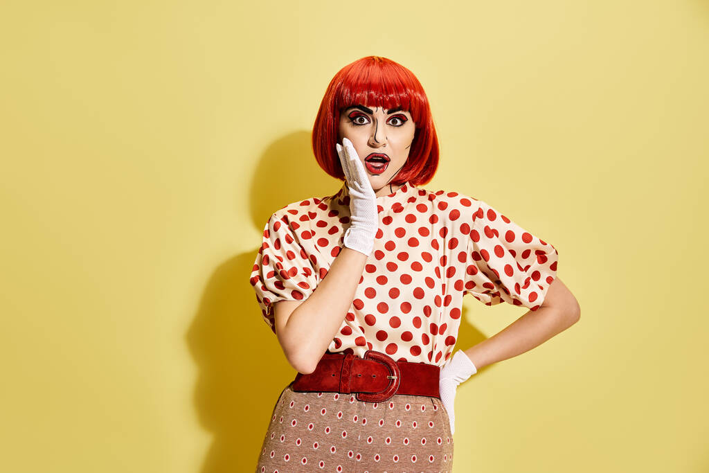A vibrant redhead with pop art makeup and a polka dot blouse against a yellow backdrop. - Photo, Image