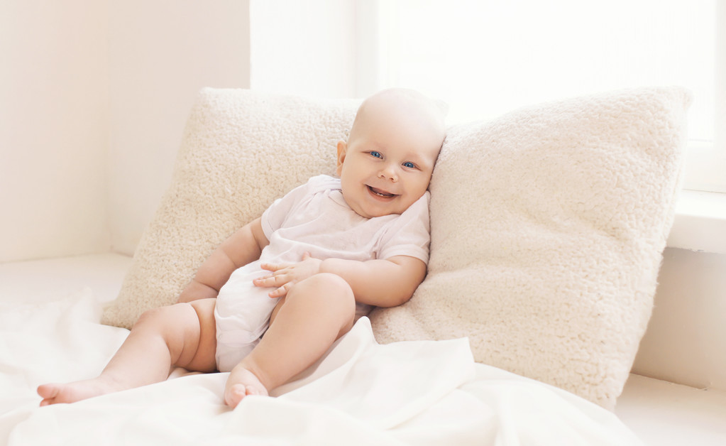 快適さ、光の自宅枕横になっている幸せな赤ちゃん - 写真・画像