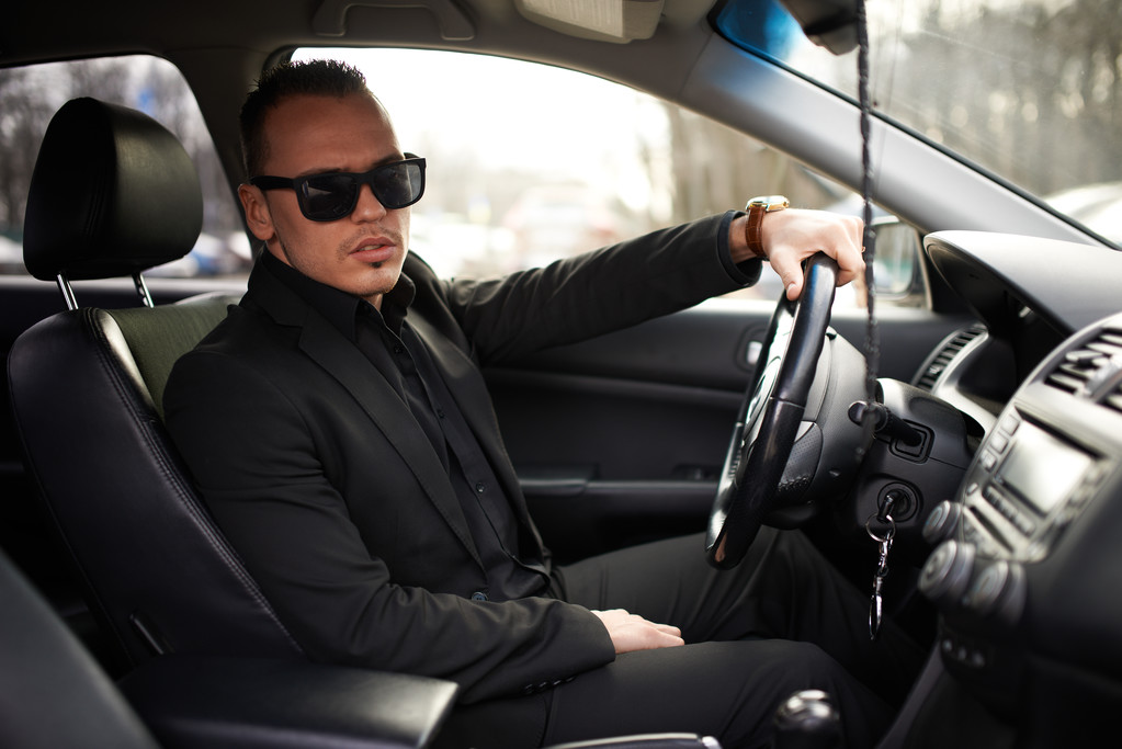 hombre de traje negro sentado detrás del volante
 - Foto, imagen