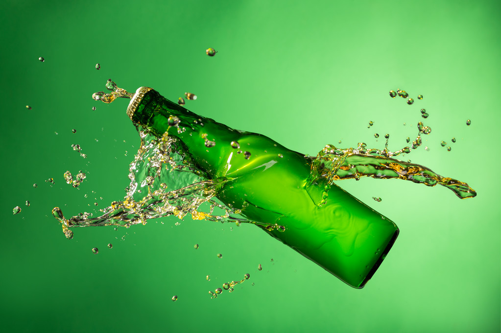 Bouteille de bière avec éclaboussure, sur fond vert
 - Photo, image