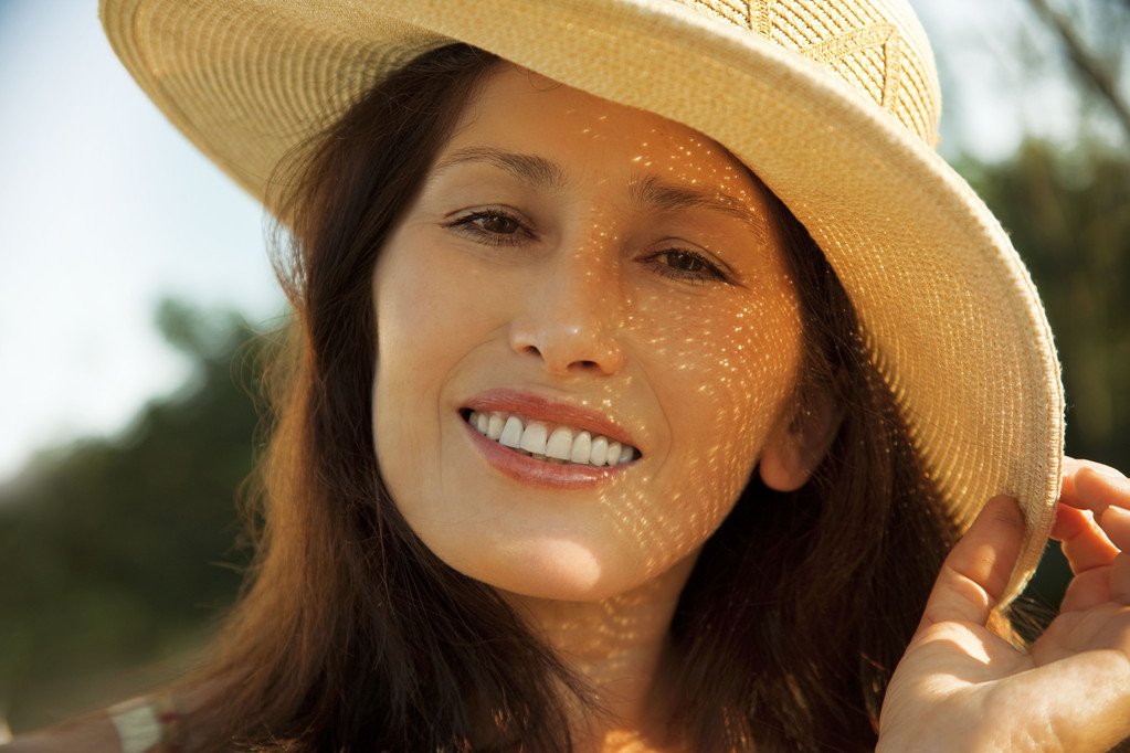 Portrait d'une femme souriante dans un chapeau, sur la nature
 - Photo, image