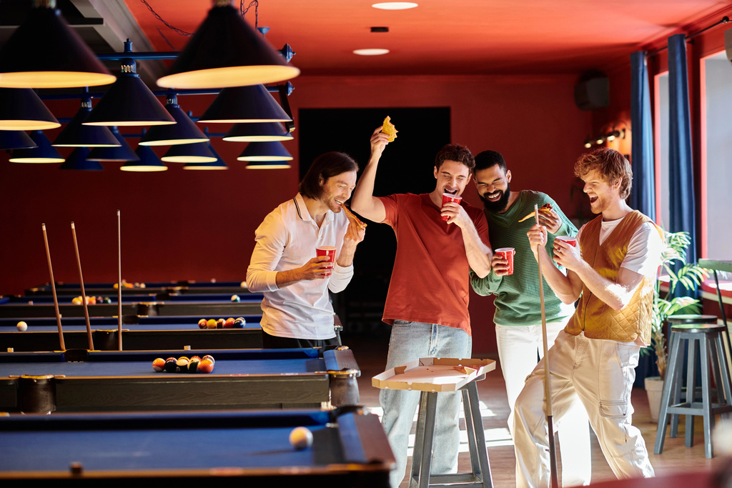 Barátok gyűlnek össze egy biliárdasztal körül, nevetnek és élvezik az alkalmi biliárd játékot egy bárban.. - Fotó, kép