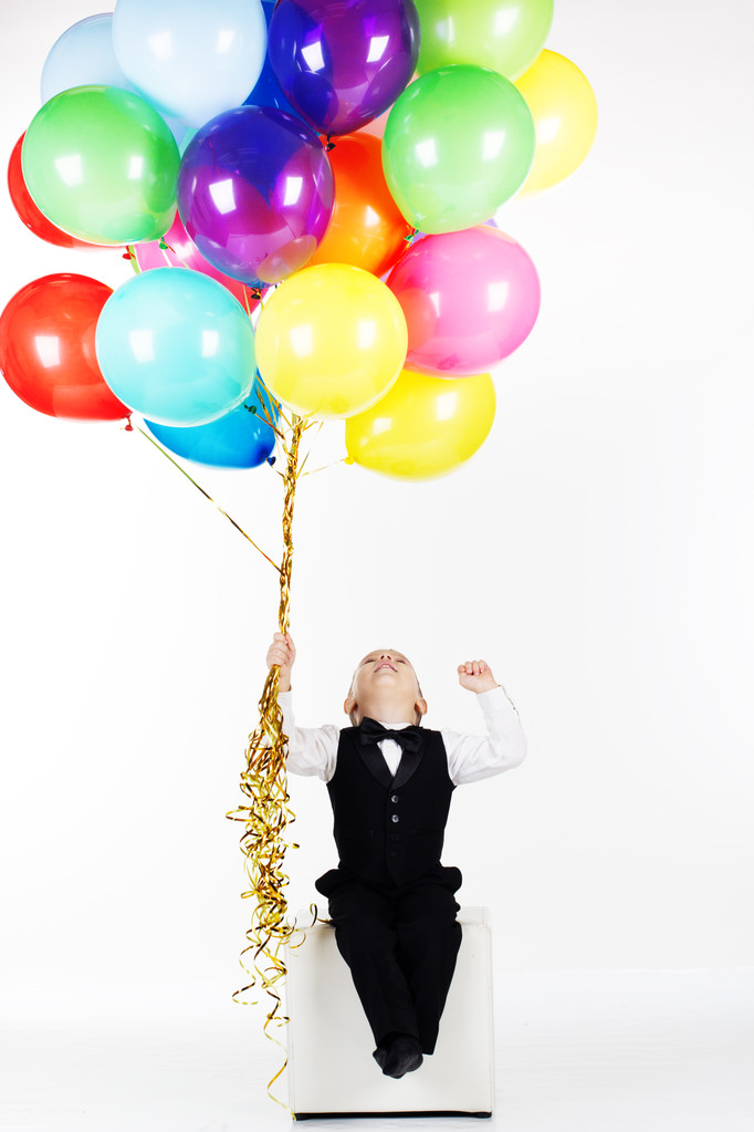 Menino feliz segurando balões coloridos
 - Foto, Imagem