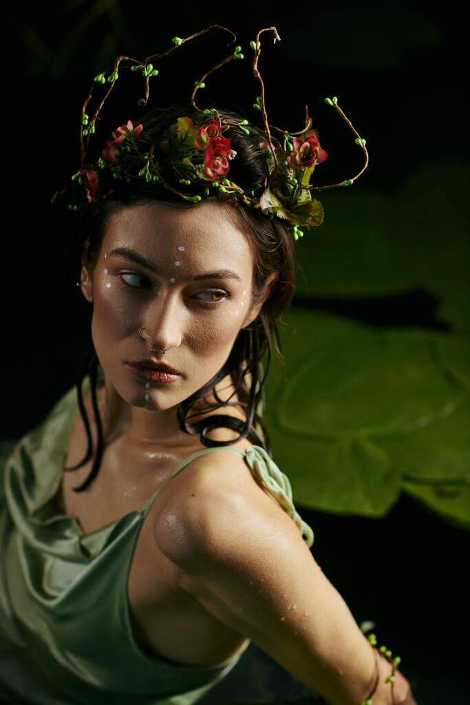Kobieta w kwiatowej koronie pozuje w pobliżu bagna, jej wyrażenie enigmatyczne. - Zdjęcie, obraz