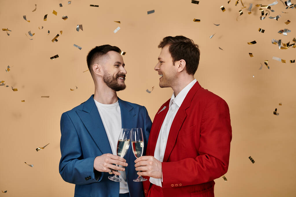 Dva muži v elegantních oblecích slaví šampaňským, obklopeni konfetami. - Fotografie, Obrázek