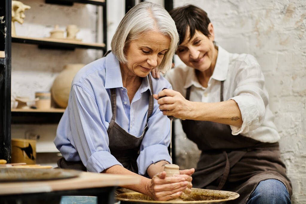 Un couple de lesbiennes mûres travaille ensemble dans un studio de poterie. - Photo, image