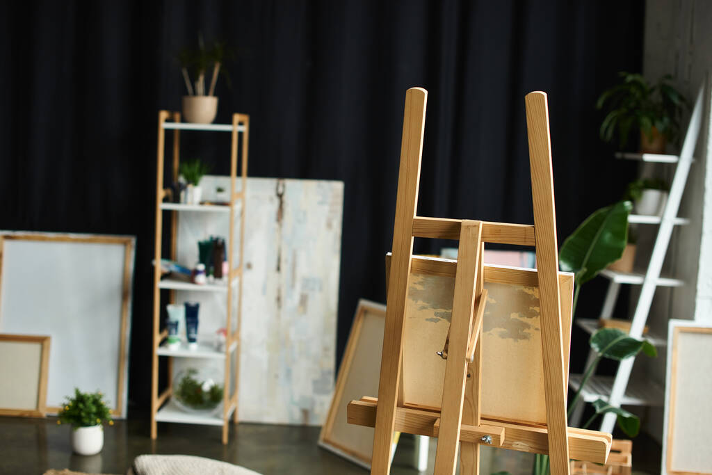 Un chevalet en bois se tient au milieu d'un atelier d'artistes, prêt pour une nouvelle création. - Photo, image