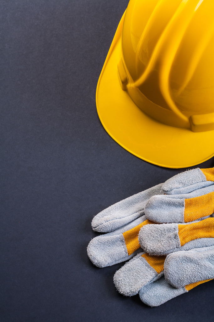Beschermende werkhandschoenen en gele helm - Foto, afbeelding