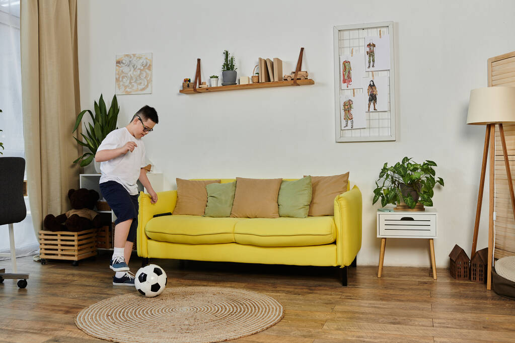 Un joven con síndrome de Down juega al fútbol en casa con sus amigos. - Foto, Imagen