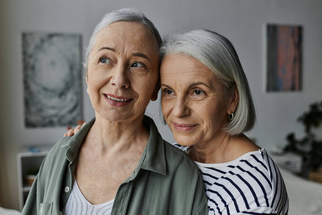 İki olgun kadın modern bir dairede birbirlerine sarılıp derin sevgilerini ve ilişkilerini gösteriyorlar.. - Fotoğraf, Görsel