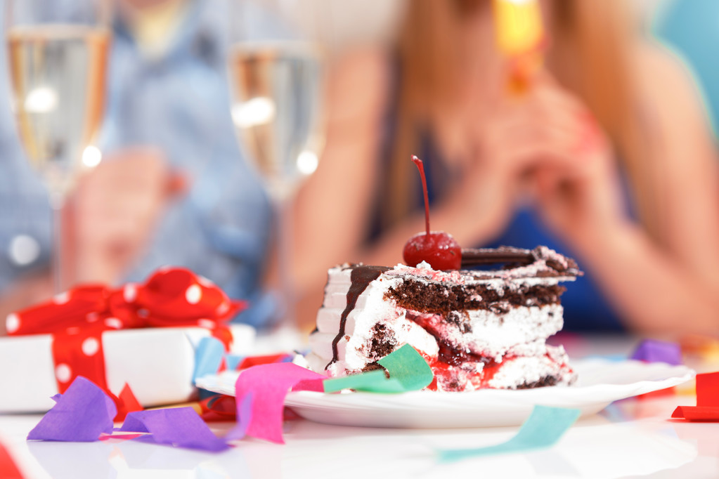 Jovens comemorando um aniversário sentados à mesa
 - Foto, Imagem