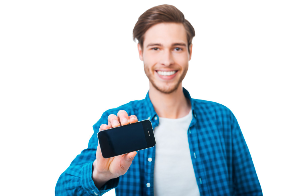 Junger Mann streckt Handy aus - Foto, Bild