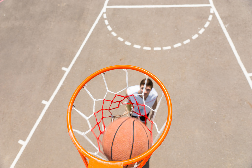 Junger Mann spielt Basketball mit Ball im Netz - Foto, Bild