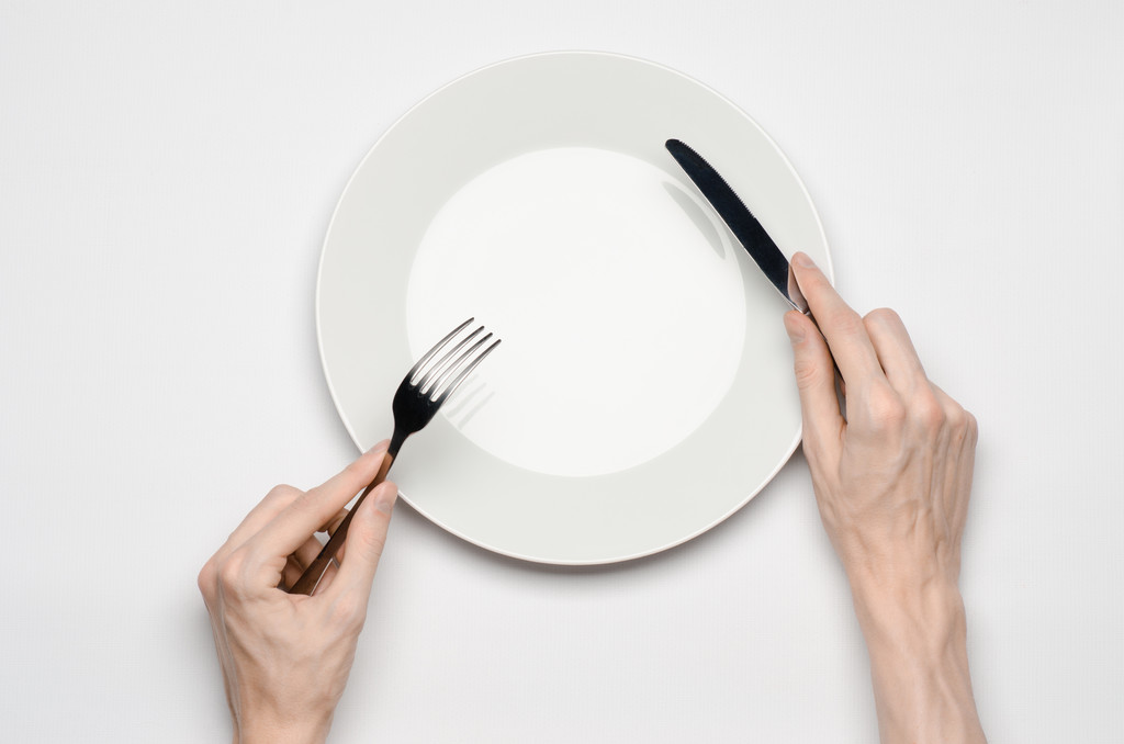 Тема ресторану та їжі: рука людини показує жест на порожній білій тарілці на білому тлі в студії ізольований вид зверху
 - Фото, зображення