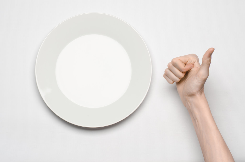 Restaurant and Food theme: the human hand show gesture on an empty white plate on a white background in studio isolated top view - Photo, Image