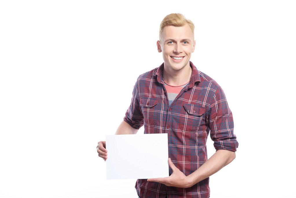 Lächelnder junger Mann mit weißem Blatt Papier  - Foto, Bild