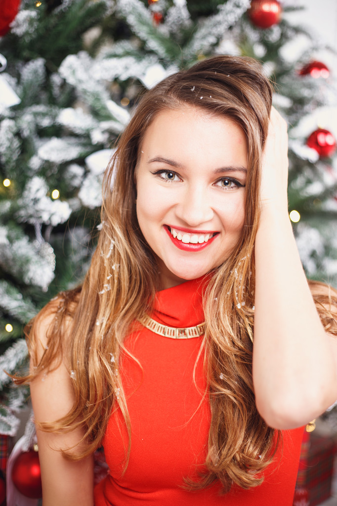Porträt der schönen süßen jungen Frau im wunderschönen Abendkleid vor weihnachtlichem Hintergrund. - Foto, Bild