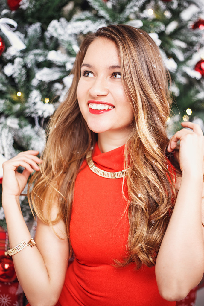 Portret van mooie zoete jonge vrouw in prachtige avondjurk over Kerstmis achtergrond. - Foto, afbeelding