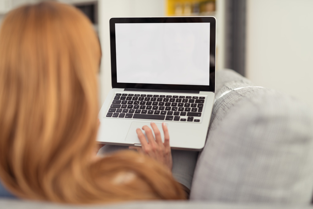 Nainen sohvalla kannettavan tietokoneen kanssa
 - Valokuva, kuva