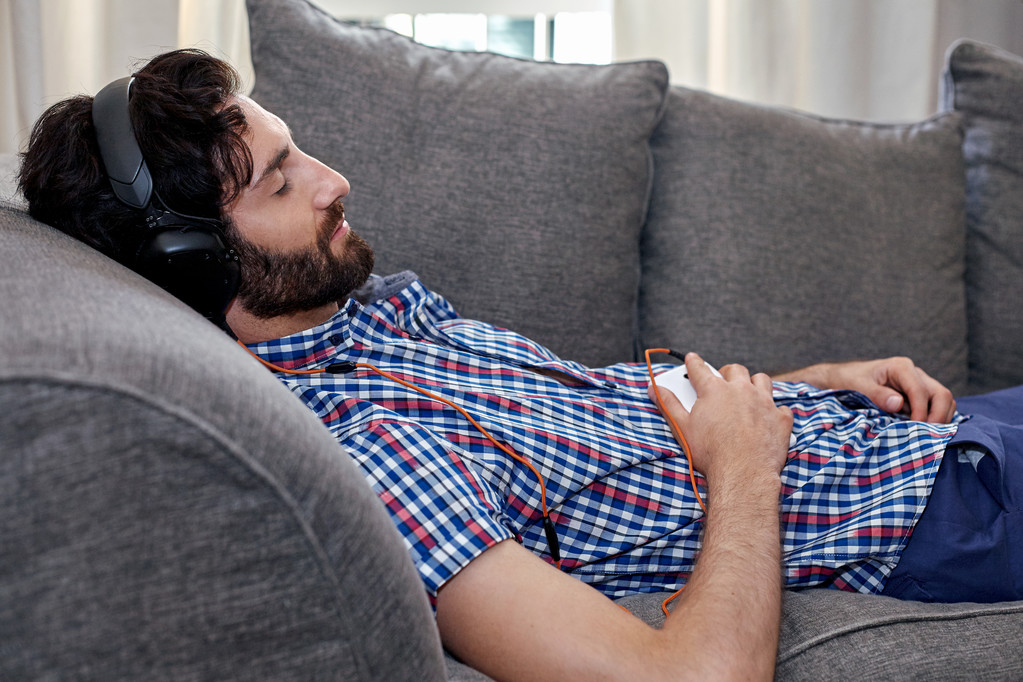 Mann hört Musik auf Sofa - Foto, Bild