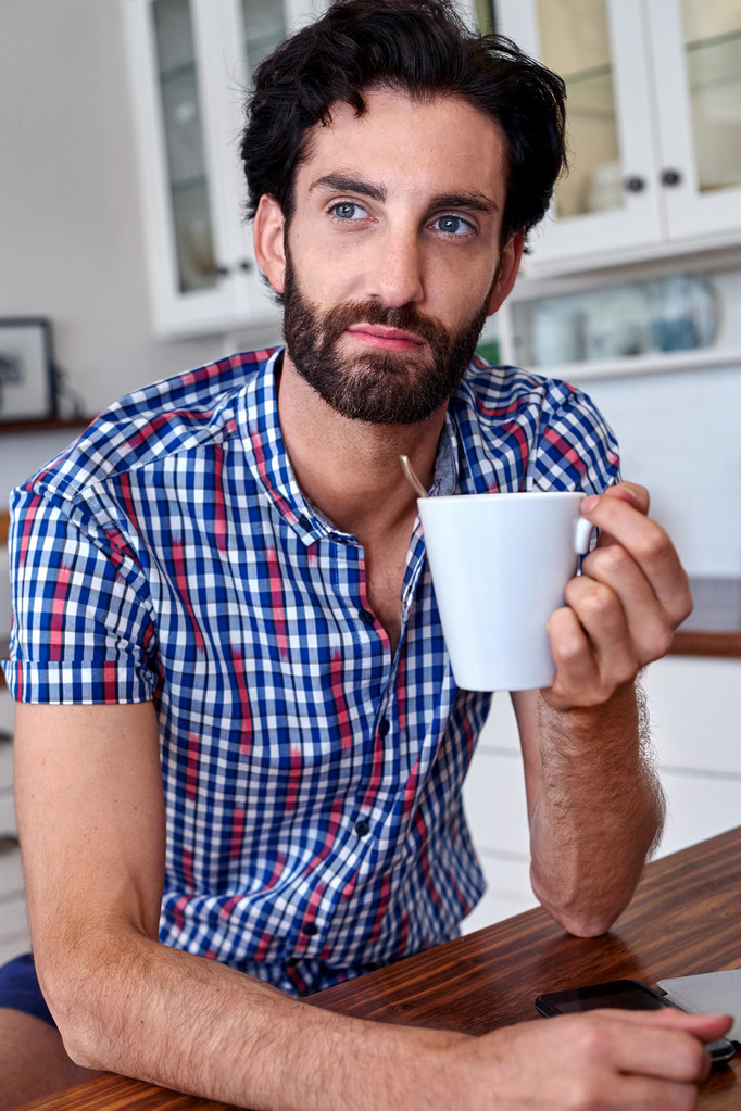 чоловік насолоджується кавою на домашній кухні
 - Фото, зображення
