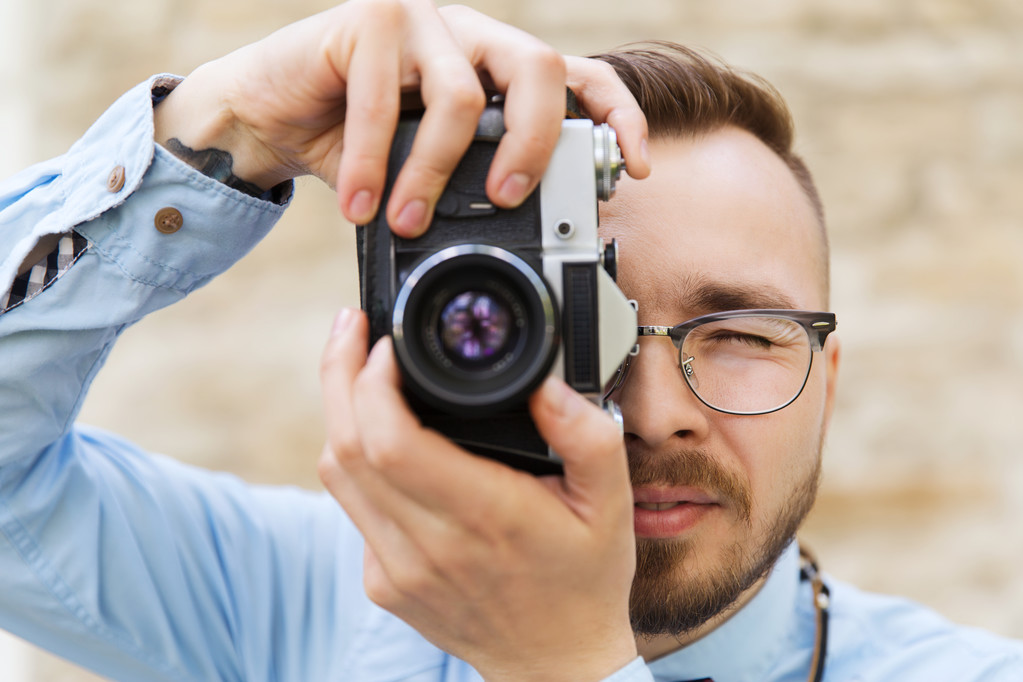 jonge hipster man met filmcamera in stad - Foto, afbeelding