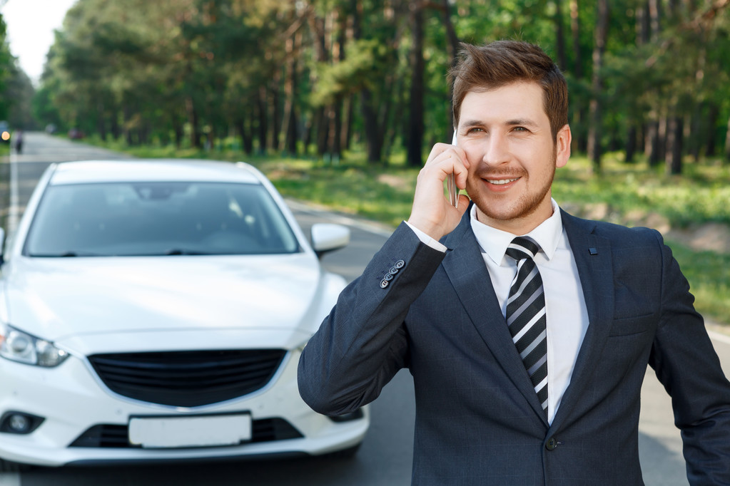 Бизнесмен говорит по мобильному телефону возле машины
 - Фото, изображение